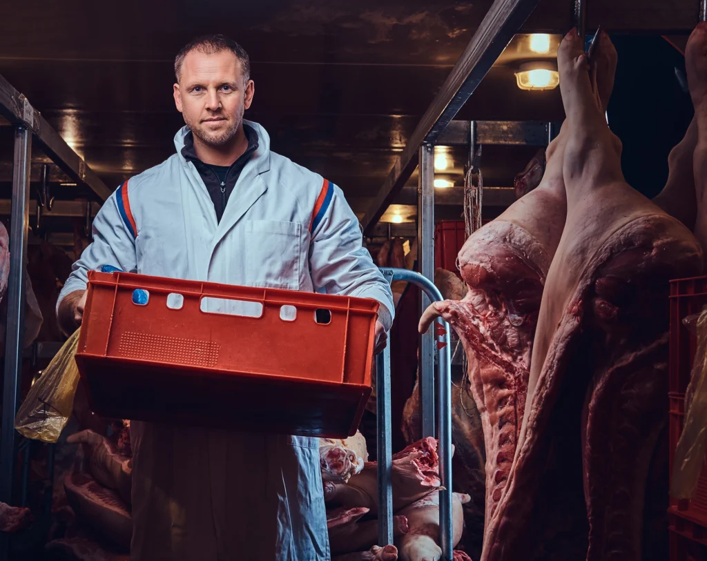Magazin 1 Metzger hält eine Kiste mit frischem Fleisch